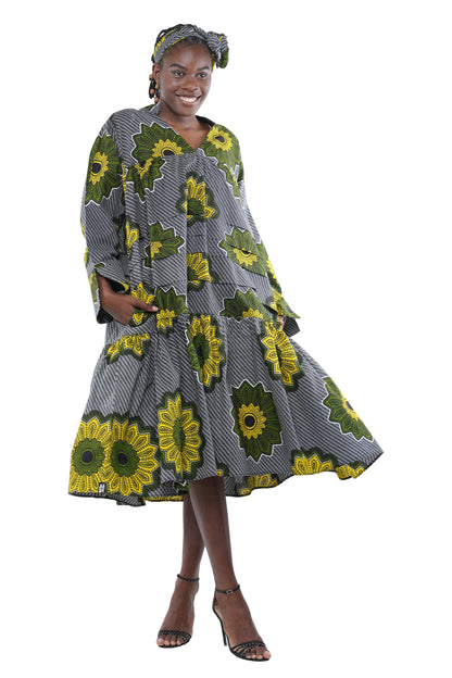 Woman wearing a gray dress with green floral patterns on a white background