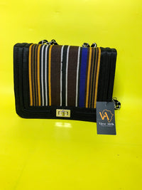 Striped handbag with a visible brand tag on a yellow background
