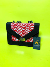 Black handbag with red and white pattern on a bright yellow background, featuring a View Afric tag.