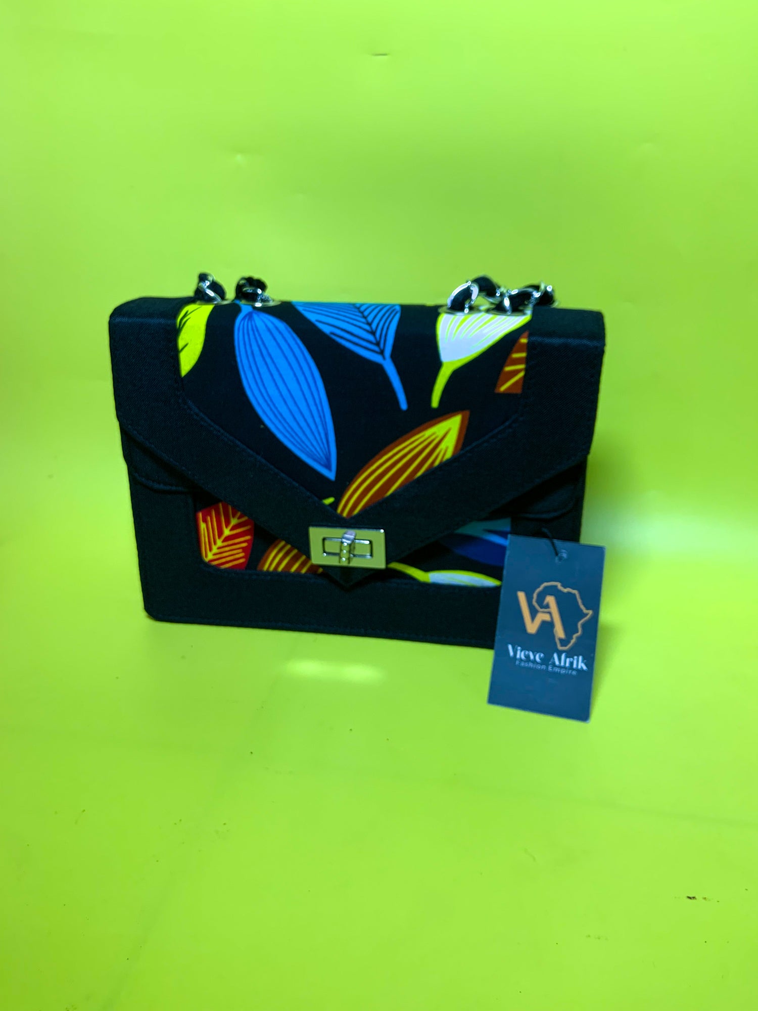 Handbag with colorful leaf pattern on a green background