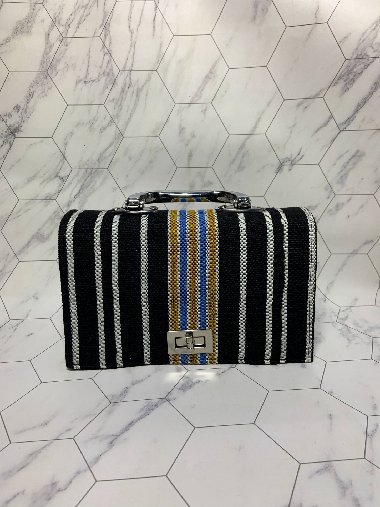 Striped handbag with a logo on a marble floor