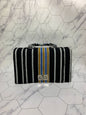 Striped handbag with a logo on a marble floor