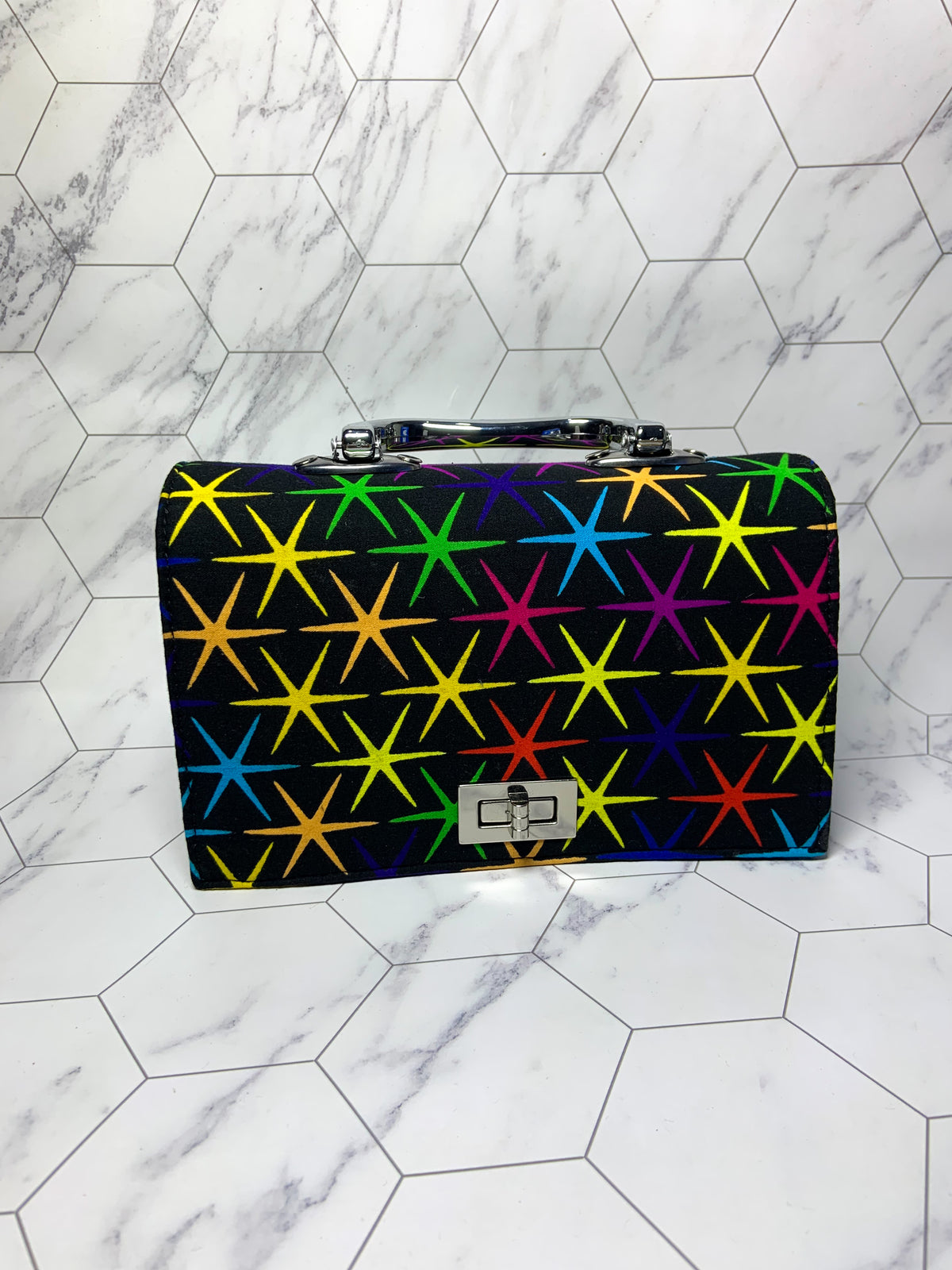 Multicolored star-patterned briefcase on a marble floor