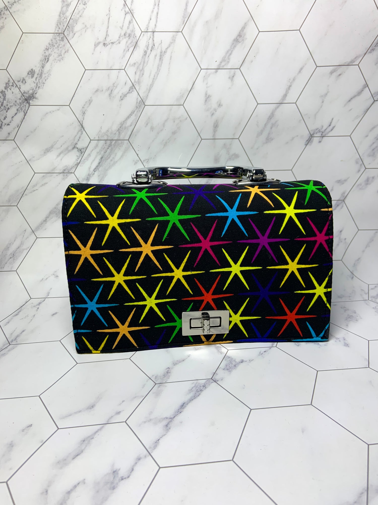 Multicolored star-patterned briefcase on a marble floor